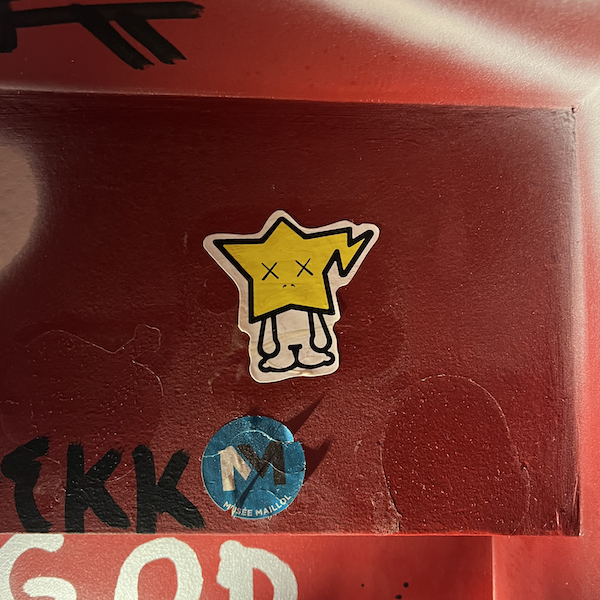 un sticker représentant un personnage avec une tête d'étoile et des yeux fatigués