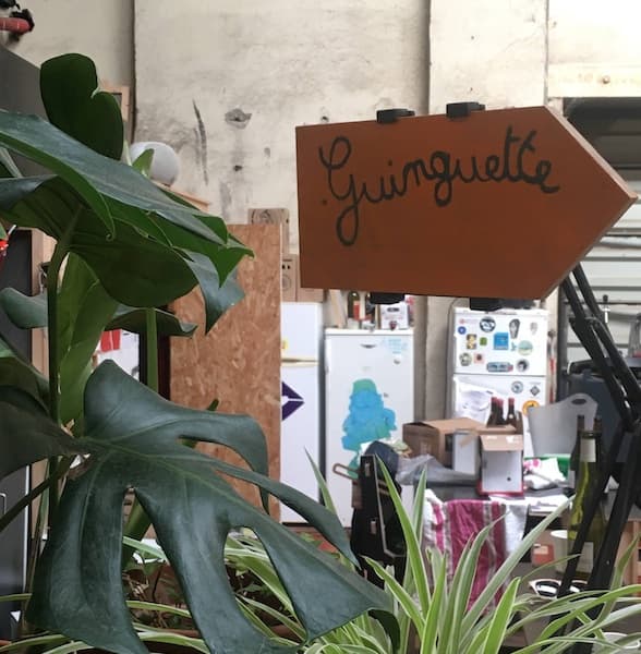 Un panneau Guinguette entouré de plantes