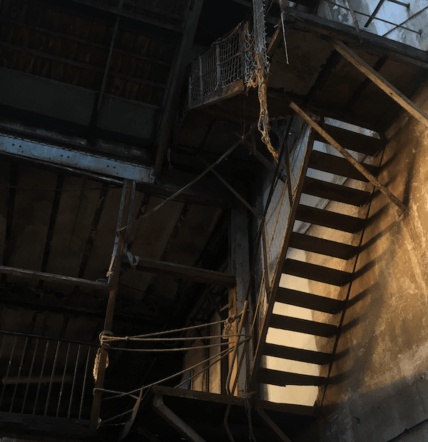 Des escaliers éclairés par la lumière du soleil couchant dans un entrepot abandonné