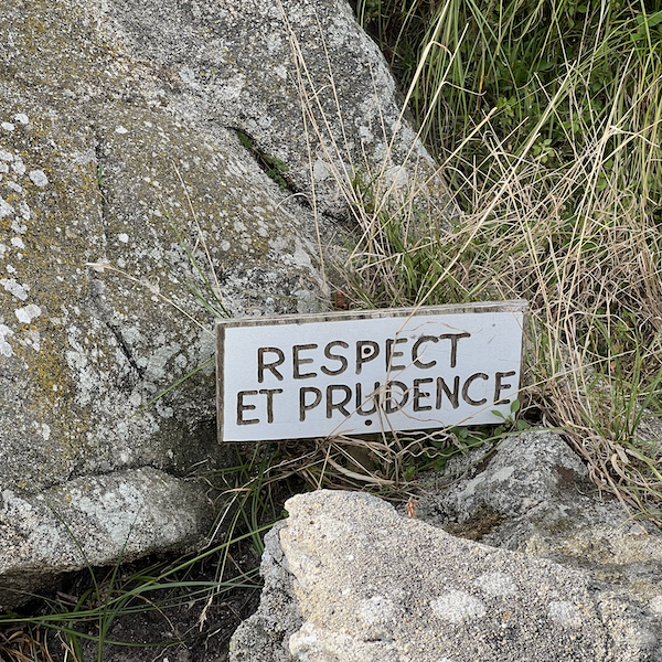 Une pancarte Respect et prudence au milieu d'un rocher