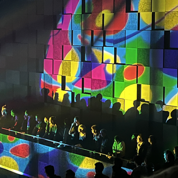 Photo d'un mur de la salle de concert Stéréolux, éclairé par un projecteur qui dessine un motif psychédélique